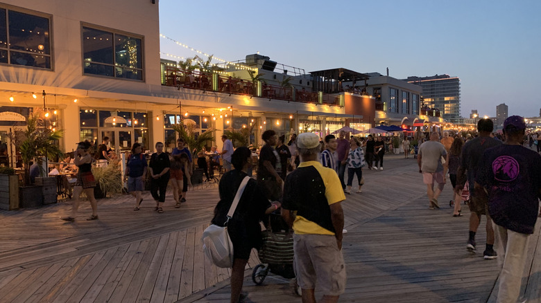 People walking on a boardwalk at sunset