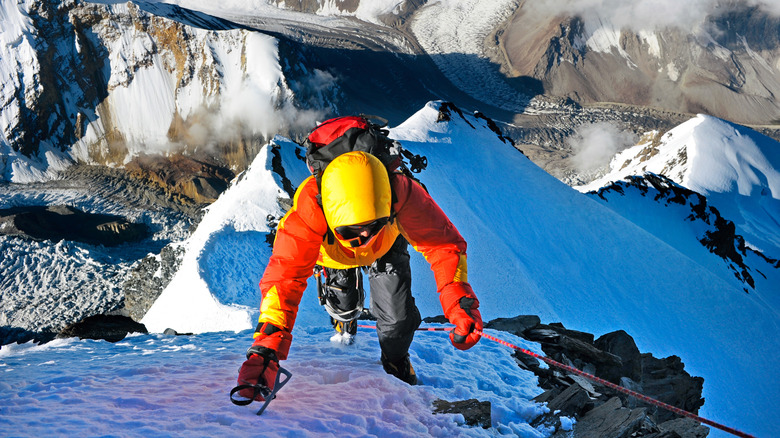 Roped mountain climber on high peak