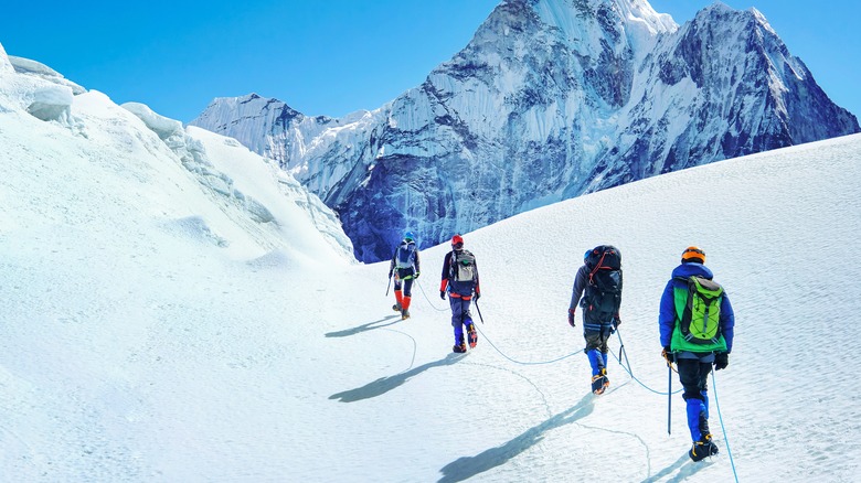 Roped climbing team crossing snowy slope