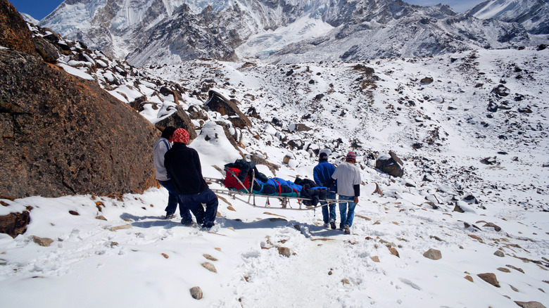 Rescue team and injured climber on slope