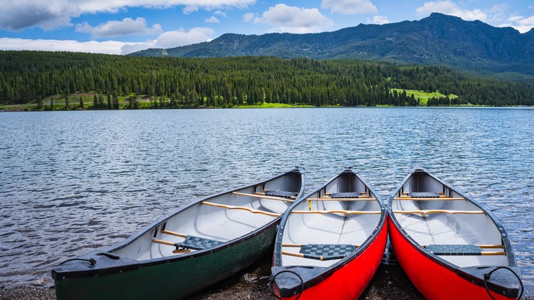 Canoes sit on the banks of the lake