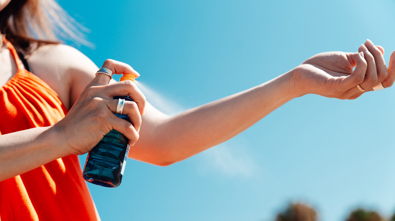Woman applying sunscreen on arm
