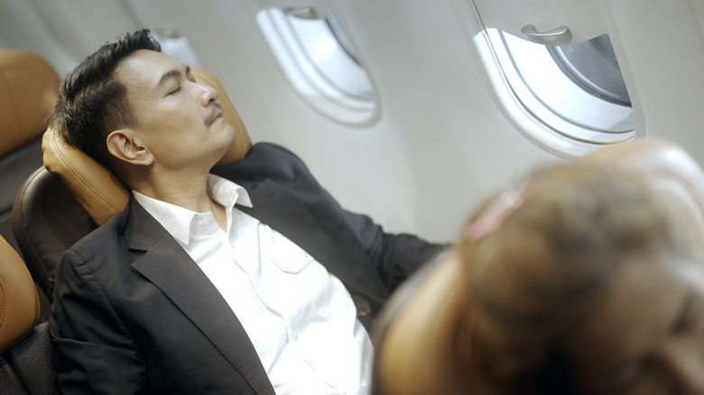 Man sleeping in plane seat
