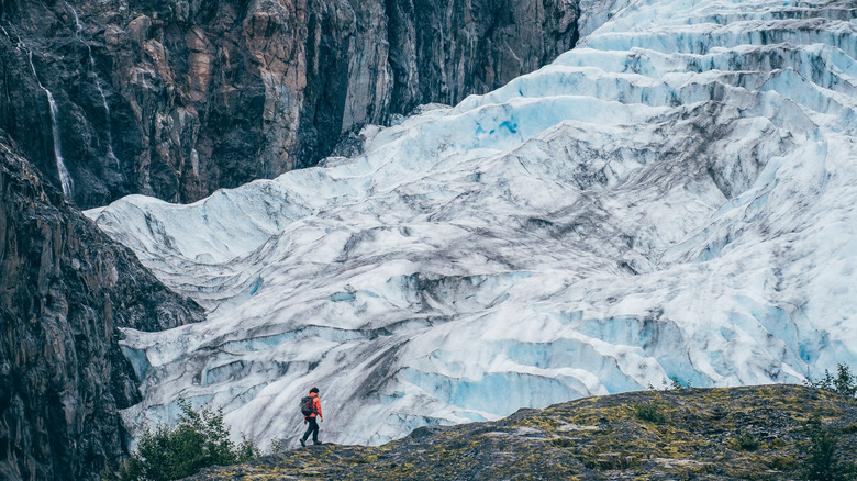 Hiker approaching enormous glacier