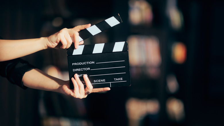 A pair of hands calls cut for a scene