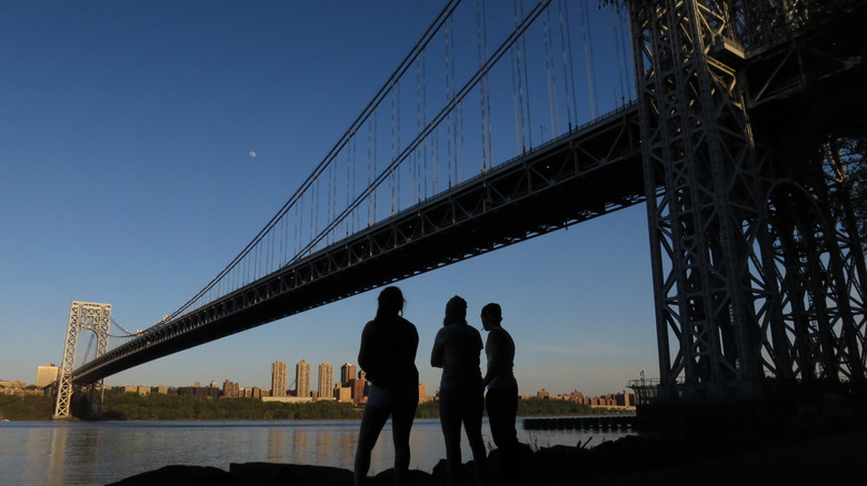 Silhouettes gazing across river GW Bridge
