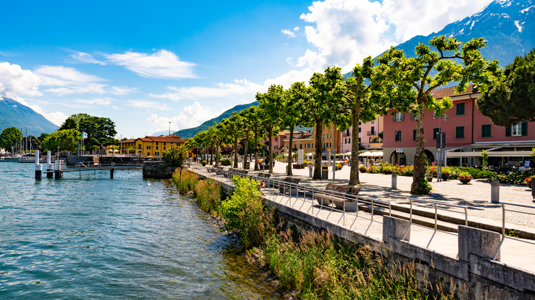 lakeside promenade with colorful buildings and trees