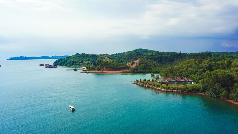Blue water and green landscape against a cloudy sky in Batam, Indonesia