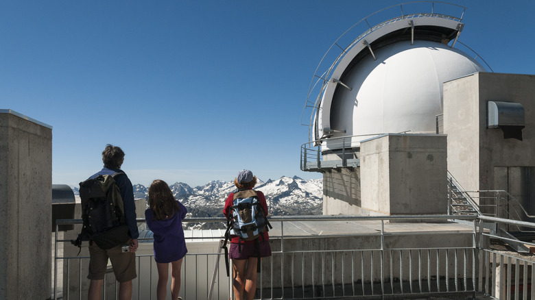 three people in an mountaintop observatory