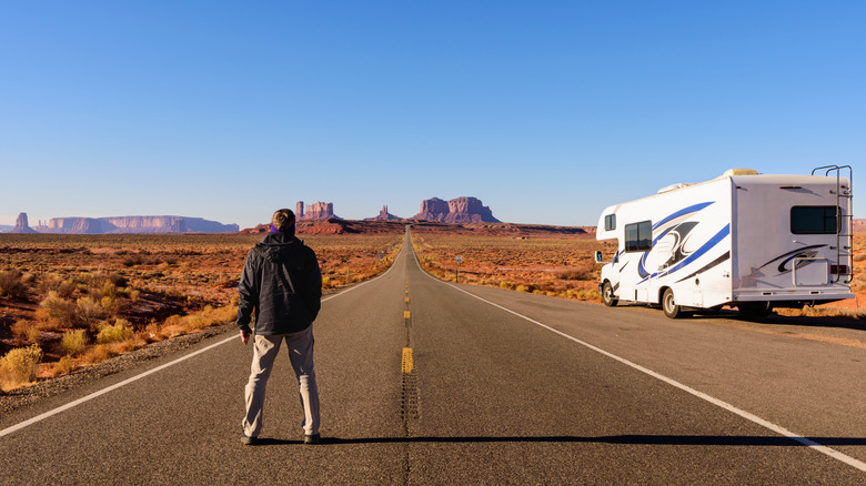 Man in wide empty road with RV
