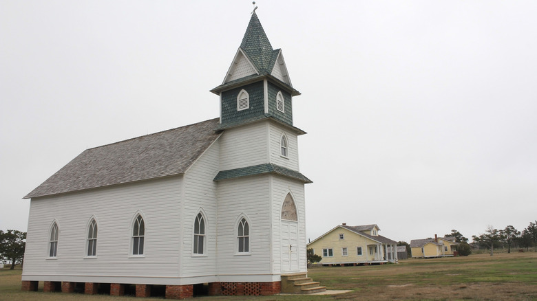 a white wooden church with arched windows