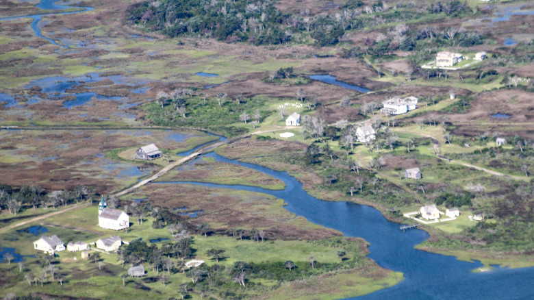 an island with abandoned houses scattered over the waterlogged land