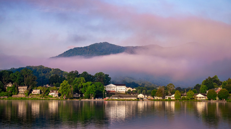 distant shot of buildings along Lake Junaluska with morning fog and mountain backdrop