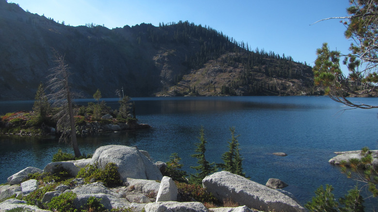 a lake with a small island and mountain in the background
