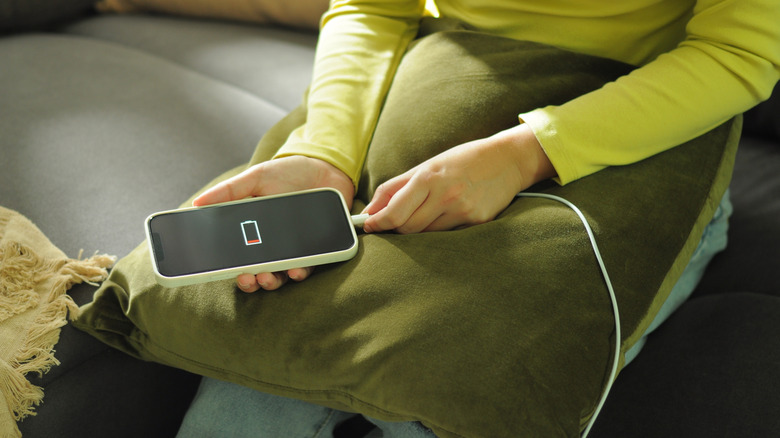 a person charging a mobile phone with low battery
