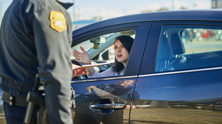 A driver looks distraught in the presence of a state trooper