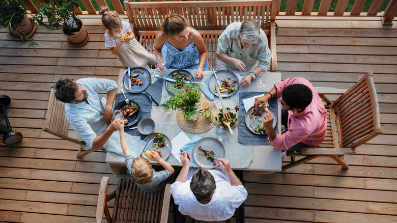 Top view of 3 generations family eating at barbecue party dinner