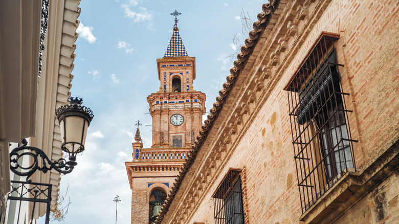 Church tower behind historic buildings in Carmona, Andalusia
