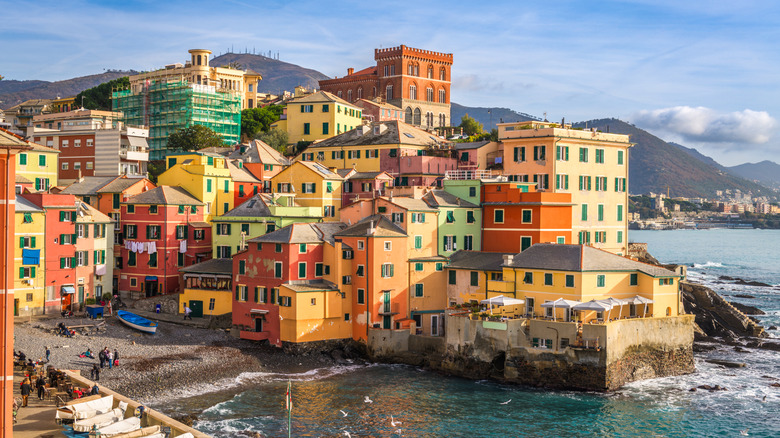 Pastel-colored multi-story buildings tightly built on a little peninsula by the sea in Bogliasco, Italy