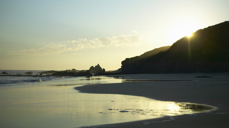 Melaque beach at sunset with cliffs silhouettted by the sun
