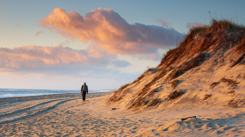 A figure walks down a beach in Salvo, North Carolina
