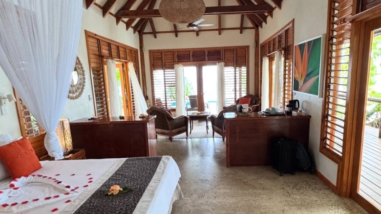 a cottage on Savasi island with heart shaped flower-pedals on the bed