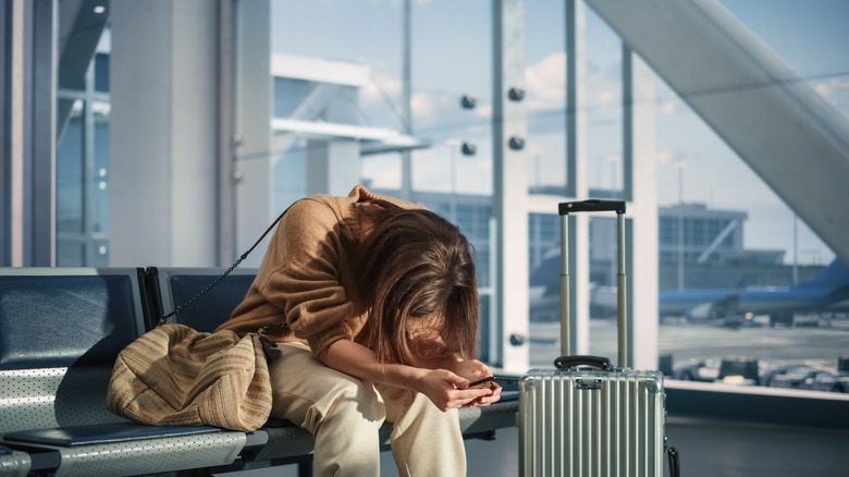 person head down airport luggage