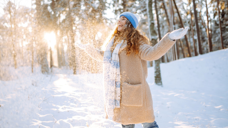 A woman enjoying the snow in a wool hat and scarf