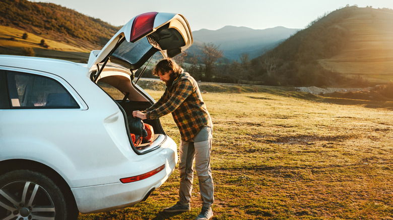 A man packs his trunk for solo camping.