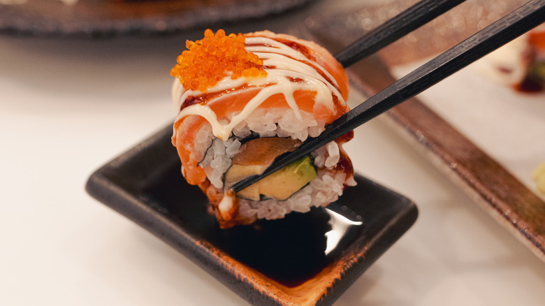 Chopsticks grabbing piece of sushi