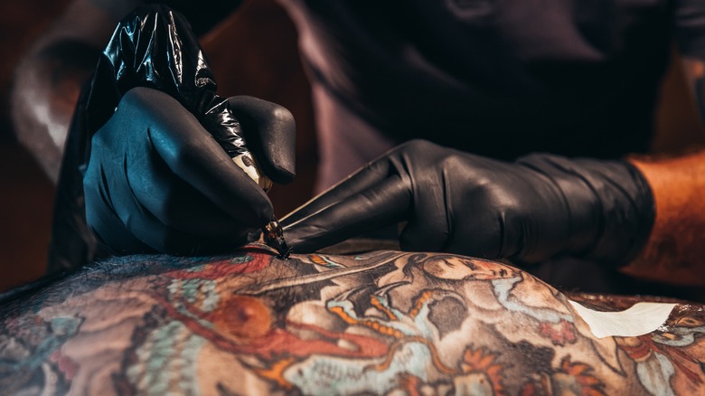 Tattoo artist working on skin