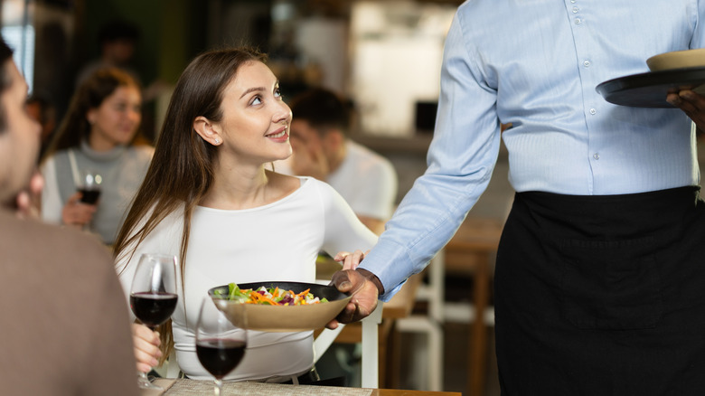 Woman being served Italian salad