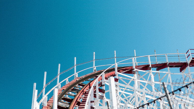 POV shot of roller coaster track climbing up against blue sky