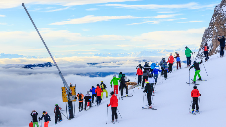 Skiers in colorful garb on peaks that seem to reach the heavens