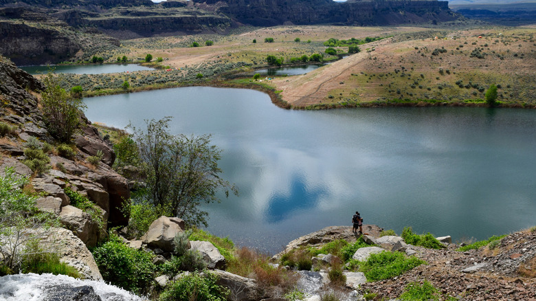 couple standing by desert lake surrounded by boulders