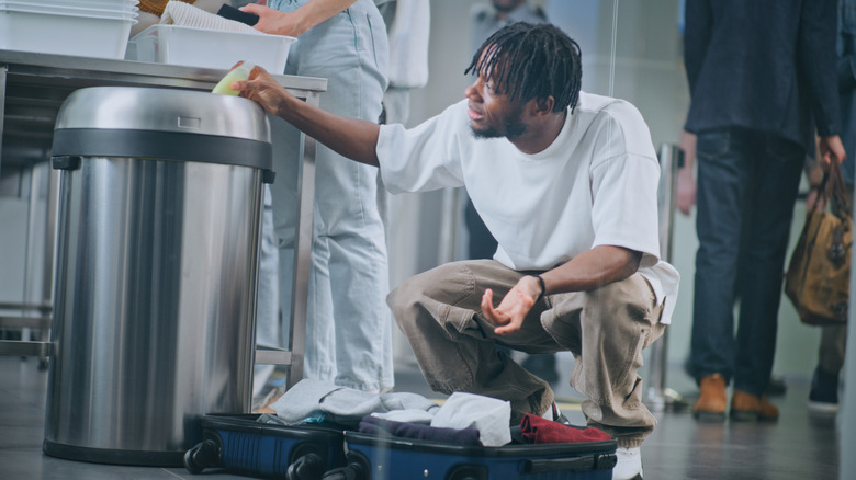 a man throwing away an item at a security check