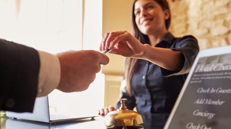 Woman handing keycard to guest