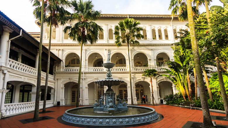 hotel courtyard with ornate fountain and palms