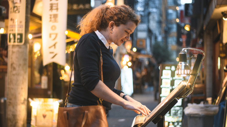 Woman looking at a menu outside of a restaurant