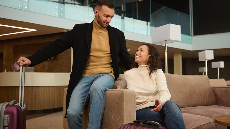 couple with suitcases in airport lounge