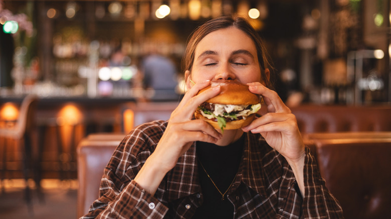 A woman holding a burger