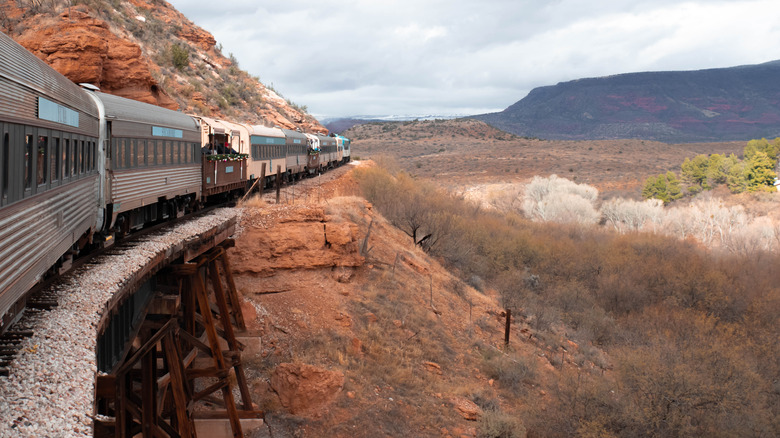 A close-up of the Verde Canyon Railroad curving around a red-rock cliff in Arizona.