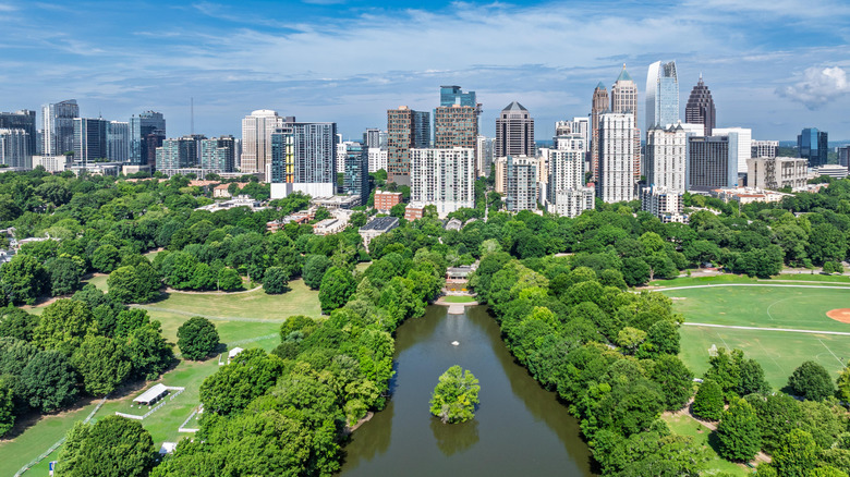 A view of the Atlanta skyline showing green spaces and trees in Piedmont Park in the foreground