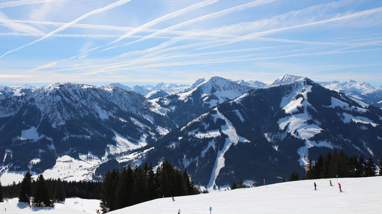 Snow-covered mountain scenery with skiers in the foreground