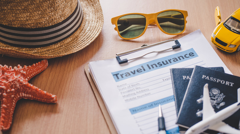 A flat lay photo of travel items, insurance and passports