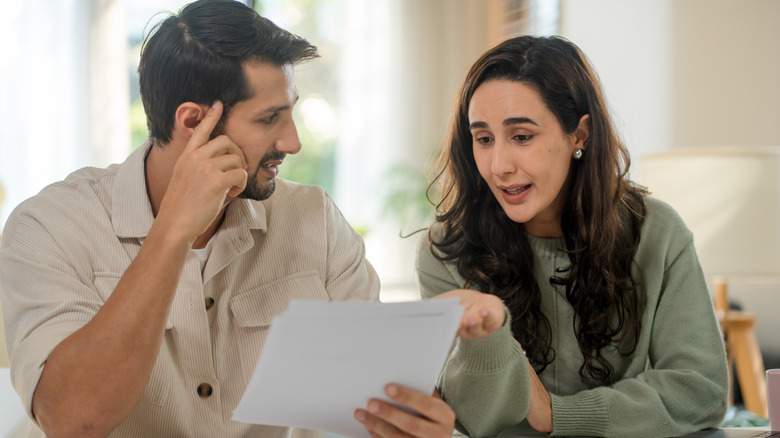A couple looking over a piece of paper together