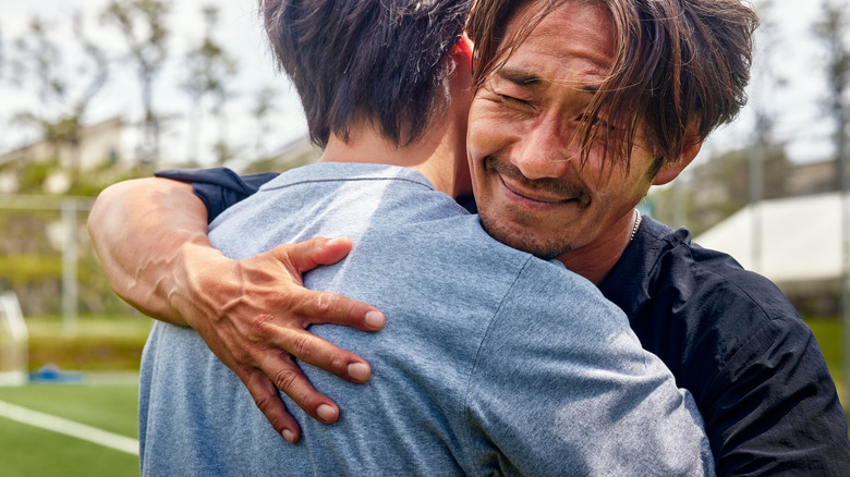 men hug each other with joyful face