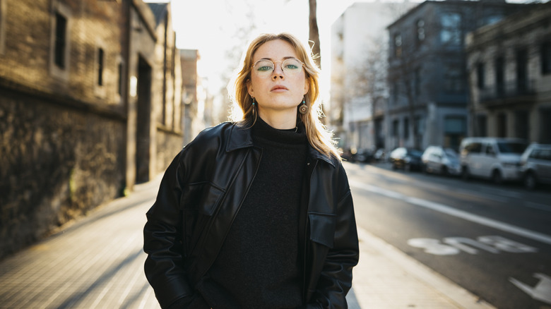 Woman in all black standing in an aloof posture