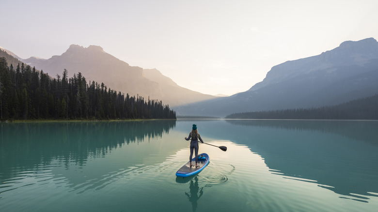 woman paddle boards on Emerald Lake in Yoho National Park