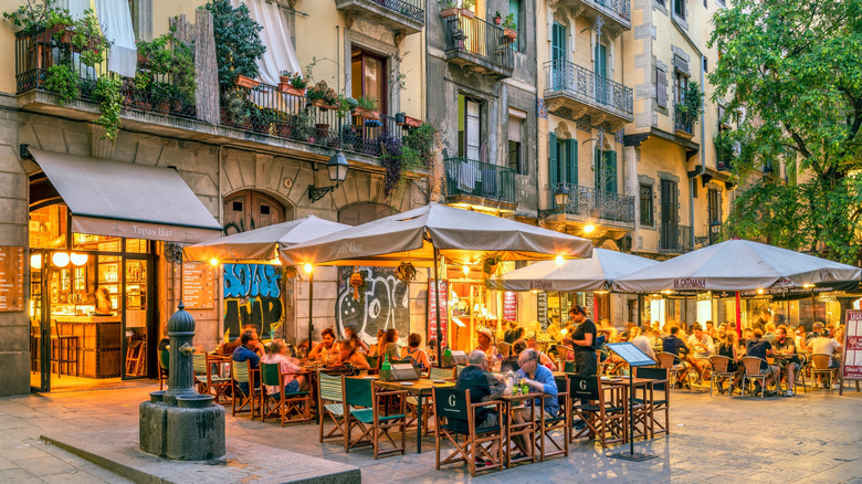 Outdoor restaurant seating with patrons sitting under umbrellas